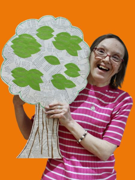 Participant and her artwork- tree with writing on it depicting her life.