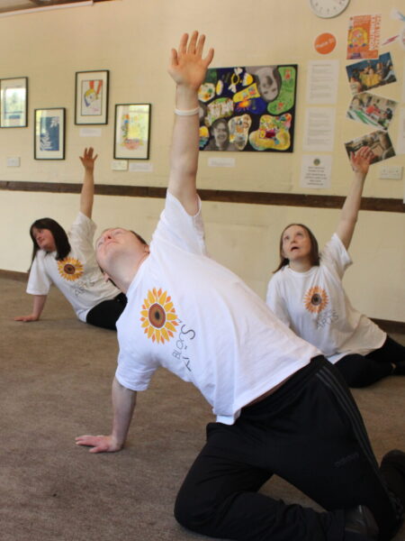 dancers moving mid dance routine with arms raised and looking upwards