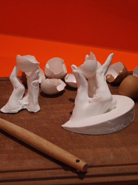 Sculpture of hands holding eggshells depicting the care needs of physically disabled participant.