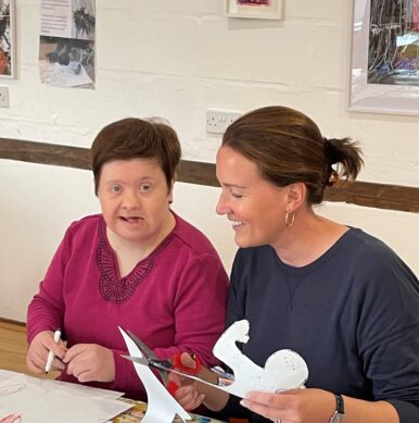 Female volunteer encouraging a participant to join in .