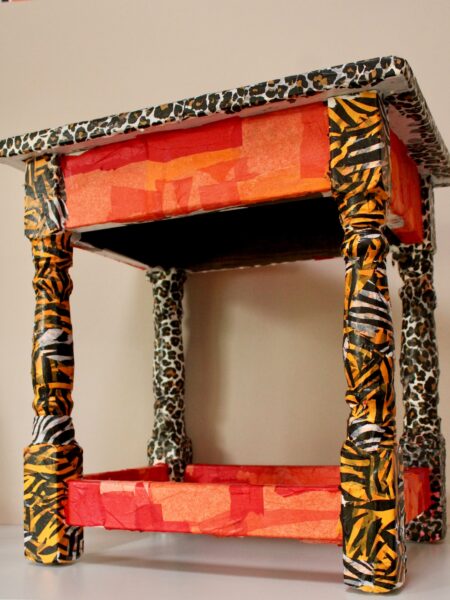 Table that has been covered in Red and animal print paper- called decoupage.